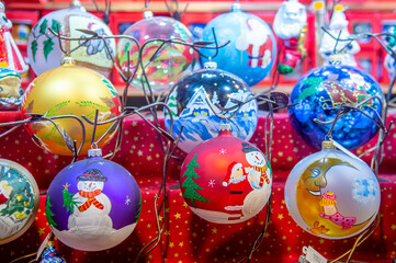 Gros plan sur des boules de Noël artisanales et multicolores. elles sont en vente dans un chalet...