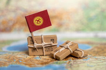 Kyrgyzstan International Shipping and Delivery Services: Small Packages with National Flag on Geographic Map Background