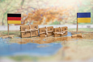 Humanitarian Aid Packages Between Germany and Ukraine: Small Parcels with Address Labels on World Map Background with National Flags