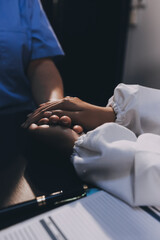 Kind male doctor wearing white coat consulting elder senior female patient holding hand of older...