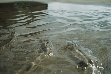 Ripples dance across the smooth surface of clear, shallow water, creating a mesmerizing pattern in natural harmony.