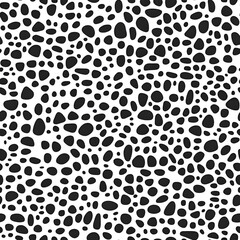 Seamless pattern with organic pebble shapes in irregular black forms on a white background, perfect for modern decor