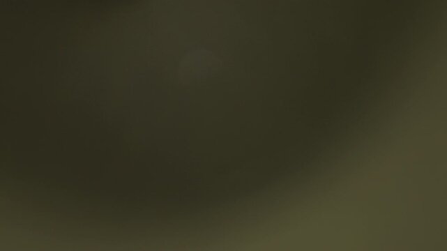 Abstract yellow lens flare appearing on black background. Slow motion. 