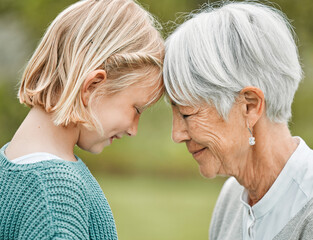 Trust, grandma and girl in park for bonding, love or peace together with senior woman or family. Nature, forehead and happy grandmother in garden with support, security or smile with kid or child