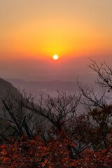 Dramatic sunset and sunrise with sun flare over mountain valley morning twilight evening sky. The incandescent round sun goes into the sunset.