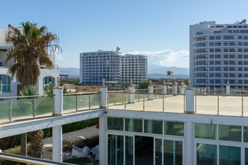 A serene view of modern architecture and surrounding palm trees on a sunlit day in a coastal town.