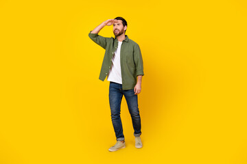 Full length portrait of nice young man look far empty space wear shirt isolated on yellow color background