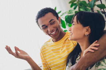 Photo of sweet loving people wear t-shirts sit couch speaking time together romantic date indoors living room