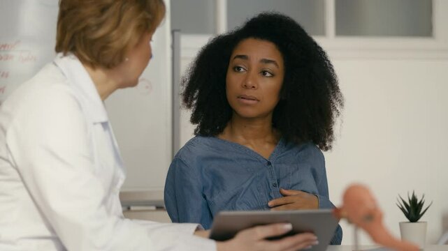 Obstetrician showing baby ultrasound image to sad pregnant woman, complications