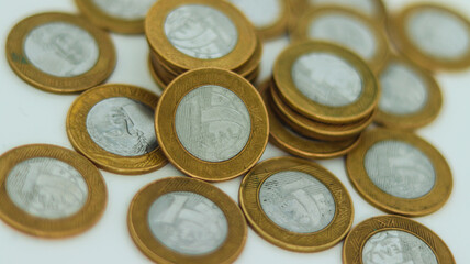 Poupança de moedas amontoadas de um real brasileiro, simbolizando finanças pessoais e economia