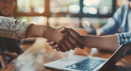 Obraz premium In a restaurant setting, a man and a woman are shaking hands warmly