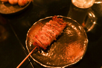 close up of Japanese grilled pork Skewers on a black plate