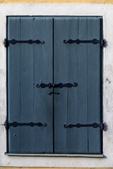 Uppsala, Sweden Grey and closed shutters on a window with old wrought-iron clasps.