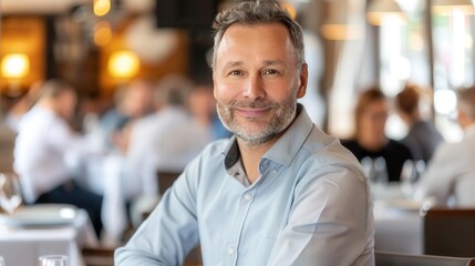 Obraz premium A man is sitting at a table in a restaurant with a smile on his face