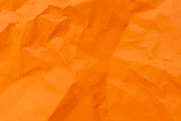 Top view and full frame of wrinkled or crumpled orange paper used as crumpled orange paper background texture.