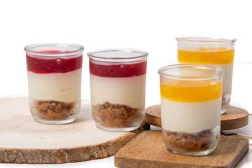 Cheesecake in a glass with raspberry coulis, delicious dessert, cheesecake with muesli and raspberry topping on white background, dessert in a glass on white background, Food concept