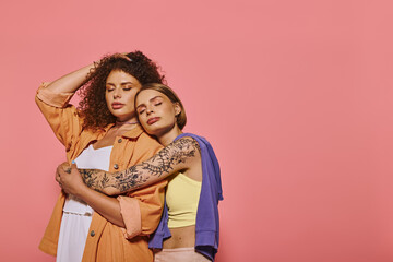 A joyful and diverse lesbian couple showcases affection and beauty in a bright studio setting.