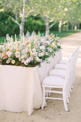 A beautifully decorated outdoor table with fresh flowers, ideal for garden parties, weddings, and elegant gatherings.