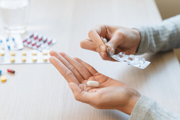Healthcare Harmony: Close-Up Hands Holding Medication and Water Glass for Optimal Wellness,...