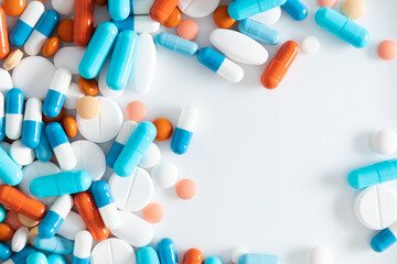 Colorful medicine pills antibiotics tablets on white background. Variety of pills and capsules. Pills of different colors and sizes. Top view. Flat lay.