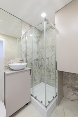 Bright Elegant Modern Luxury Home Bathroom Interior Design With White Sink. Marble Gray Walls, Mirror and Faucet. LED Lights. Shower Area, Heater, Tile Floor and Walls