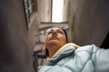 Fototapeta premium Low angle view of person in narrow urban alley with dramatic perspective