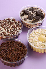 Various chocolate cakes in a jar on a lilac background