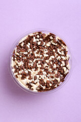 White and dark chocolate cake seen from above on a lilac background