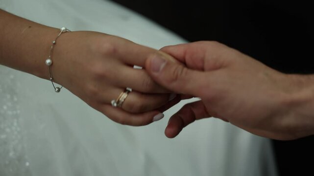 bride's hand with a wedding ring on a wedding dress