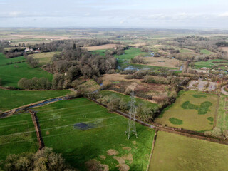 aerial view of an electricity pylon and line in open rural countryside in the UK