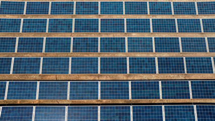 Fototapeta premium Aerial view of many solar panels on a sunny day. They are located on the roof of a building.
