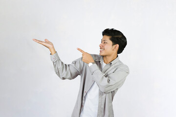 Young Teenager in shirt and vest gives expression of happiness and sadness points with gestures with hands