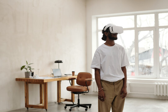 Young male architect wearing VR headset, engaged in virtual activity