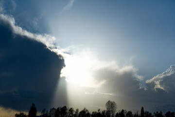 Kyrgyzstan, Karakol. A gloomy view of the setting sun behind heavy storm clouds on the shore of...