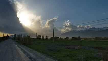 Kyrgyzstan, Karakol. A gloomy view of the setting sun behind heavy storm clouds on the shore of Lake Issyk-Kul.