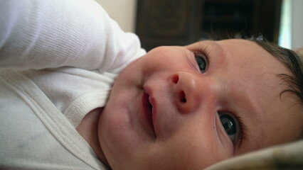 Baby lying down, gazing upwards with a peaceful and thoughtful expression. close-up captures the...
