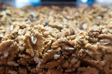 Walnut background. Peeled walnuts on display at a grocery store. Closeup view on shelled walnuts selling by weight in food store.