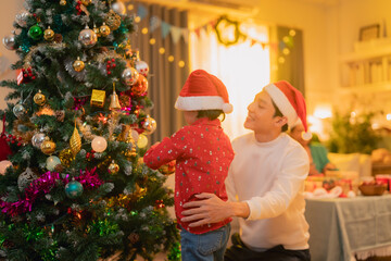 Creating description and keywords for imageA joyful scene of man and child decorating Christmas...