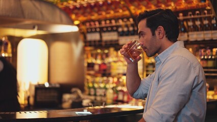 Profile closeup of smiling smart man in white shirt drinking cocktail in Old fashioned of special party beverage vibrant at nightclub on Friday meeting night time at luxurious counter bar. Vinosity.