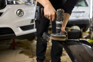 Automotive Maintenance Expertly Polishing Car Parts in the Workshop for a Gleaming Finish