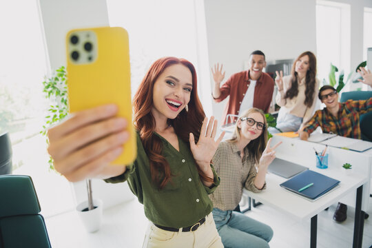 Photo of cheerful friendly young it coworkers enjoying education together recording video modern device indoors workplace workshop