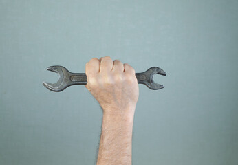 Male hand holding metal wrench. Working tool