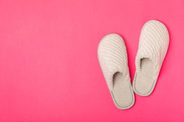 Soft slippers on a bright colored background, close-up. House slippers. Comfortable shoes for home. Foot care concept. Home comfort. Space for text. Copy space.