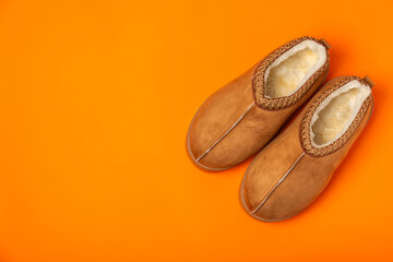 Fototapeta premium Soft slippers on a bright colored background, close-up. House slippers. Comfortable shoes for home. Foot care concept. Home comfort. Space for text. Copy space.