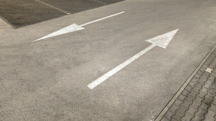 Two arrows drawn on asphalt. Road signs on the road.