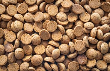 Pile of Kruidnoten filling the entire frame, background with dutch cookies traditionally associated with Sinterklaas