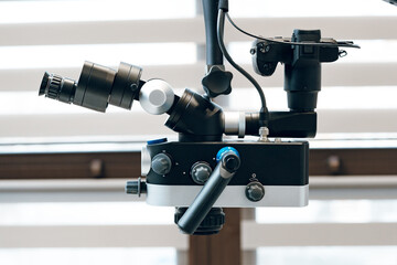 A detailed view of a dental microscope prepared for a procedure in a dental clinic
