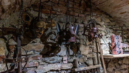 Scold's bridle hanging from a brick wall in an abandoned castle