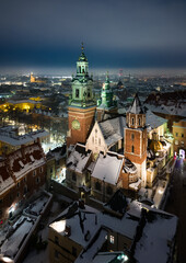 Aerial view of snowy Wawel castle and Wawel cathedral from a drone on a cold winter night