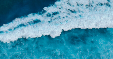 Turquoise ocean sea water white wave splashing deep blue sea. Bird eye view monster wave splash on rock. Tropical sea beach in summer seaside outdoor. Ocean island beautiful dramatic landscape.
